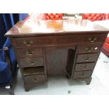 Reproduction mahogany and crossbanded kneehole desk with a long drawer above a cupboard door flanked