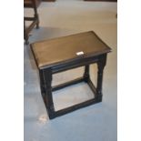 Reproduction dark oak joint stool raised on turned supports with stretchers