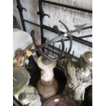 Patinated metal armillary sphere mounted on a cast concrete pedestal