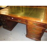 Victorian oak twin pedestal desk with a tooled green leather inset top above nine drawers on