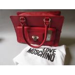 Love Moschino, red leather handbag having pocket to front with silver metal padlock style clasp