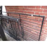 Modern black painted iron garden panel with scroll work decoration fitted on iron posts, together