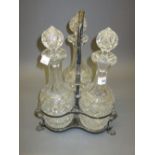 Set of three cut glass decanters with stoppers on a silver plated stand Chips to rim and bases on