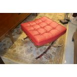 Modern red buttoned leather upholstered stool on crossover chrome supports in Barcelona style