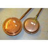 19th Century copper warming pan with turned wooden handle together with another later copper warming