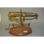 Reproduction brass decanting cradle on a mahognay stand