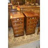 Pair of mahogany slim chests of five drawers with circular brass ring handles, raised on plinth