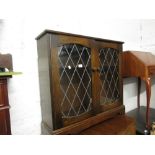 Late 20th Century oak bookcase having adjustable shelves and two leaded glazed doors on a shaped