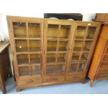 Mid 20th Century oak three door glazed bookcase with drawers below raised on bracket feet Good
