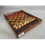 Early 20th Century mahogany cased travelling chess set with natural and red stained bone pieces by