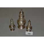 London silver baluster form pepper and two similar smaller condiments