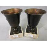 Pair of Art Deco patinated metal side urns on marble plinth bases