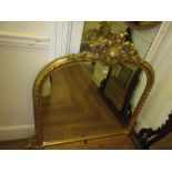 Reproduction gilt framed overmantel mirror with a pierced floral surmount