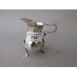 Small 18th Century London silver cream jug with C-scroll handle on shaped supports