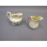Belleek shell form porcelain jug with coral handle together with a Belleek cream jug (both with '