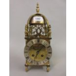 Gilt brass lantern type clock with silvered dial and Roman numerals, the two train Japy Freres
