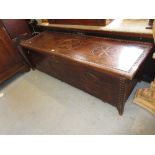 Mid 20th Century African hardwood coffer with hinged lid decorated with circular motifs, 63ins wide