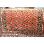 Pakistan rug of Turkoman design with two rows of gols on a rust ground with borders