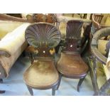 Pair of Regency mahogany hall chairs, the carved shell backs (one with damages and losses)