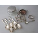 Silver toast rack, tea strainer, six teaspoons, napkin ring, silver mounted dressing table jar and