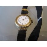 Ladies circular 9ct gold cased wristwatch on a linen strap, the movement by Dreadnought