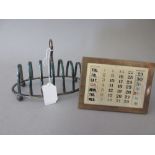 Sheffield silver six division oval toast rack and a silver mounted perpetual calendar