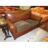 Early 20th Century brown leather upholstered two seater sofa with matching chair raised on turned