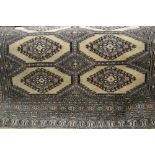 Pakistan rug of Turkoman design, two rows of eight gols on a beige ground with borders, 81ins x