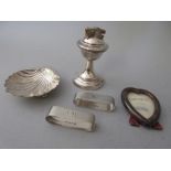 Silver mounted cigarette lighter, shell form butter dish, two napkin rings and a miniature heart