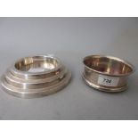 Circular silver bottle coaster together with a plated bottle coaster