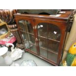 Mid 20th Century mahogany display cabinet with two glazed doors, raised on low cabriole supports