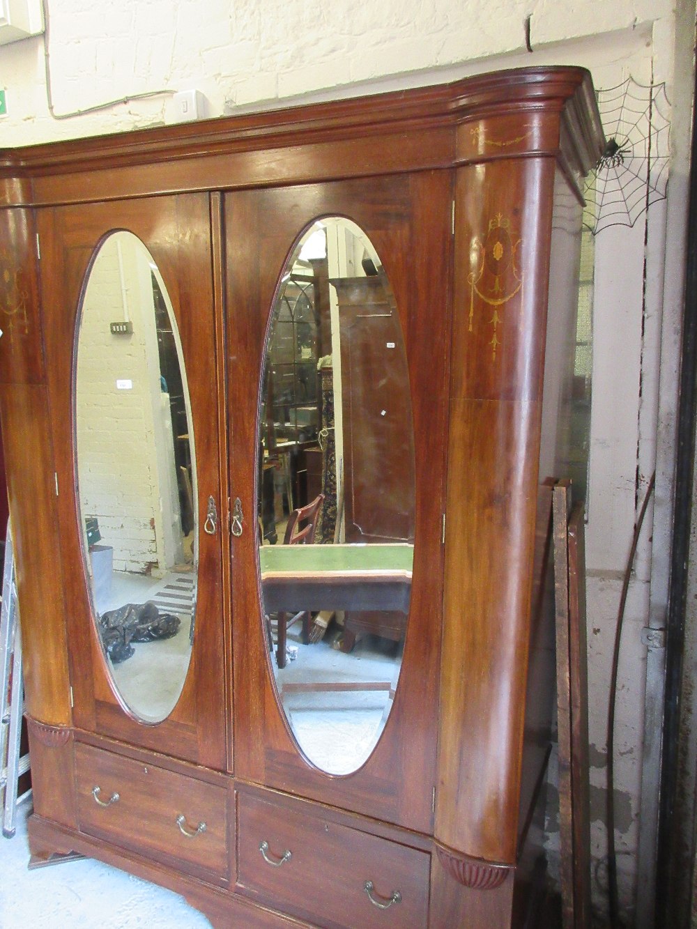 Edwardian mahogany wardrobe having inlaid decoration, the moulded cornice above two oval inset