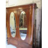 Edwardian mahogany wardrobe having inlaid decoration, the moulded cornice above two oval inset