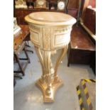 Reproduction patinated carved wooden circular font style jardiniere stand on three scroll supports