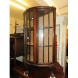 20th Century mahogany bow fronted single door display cabinet on carved cabriole claw and ball