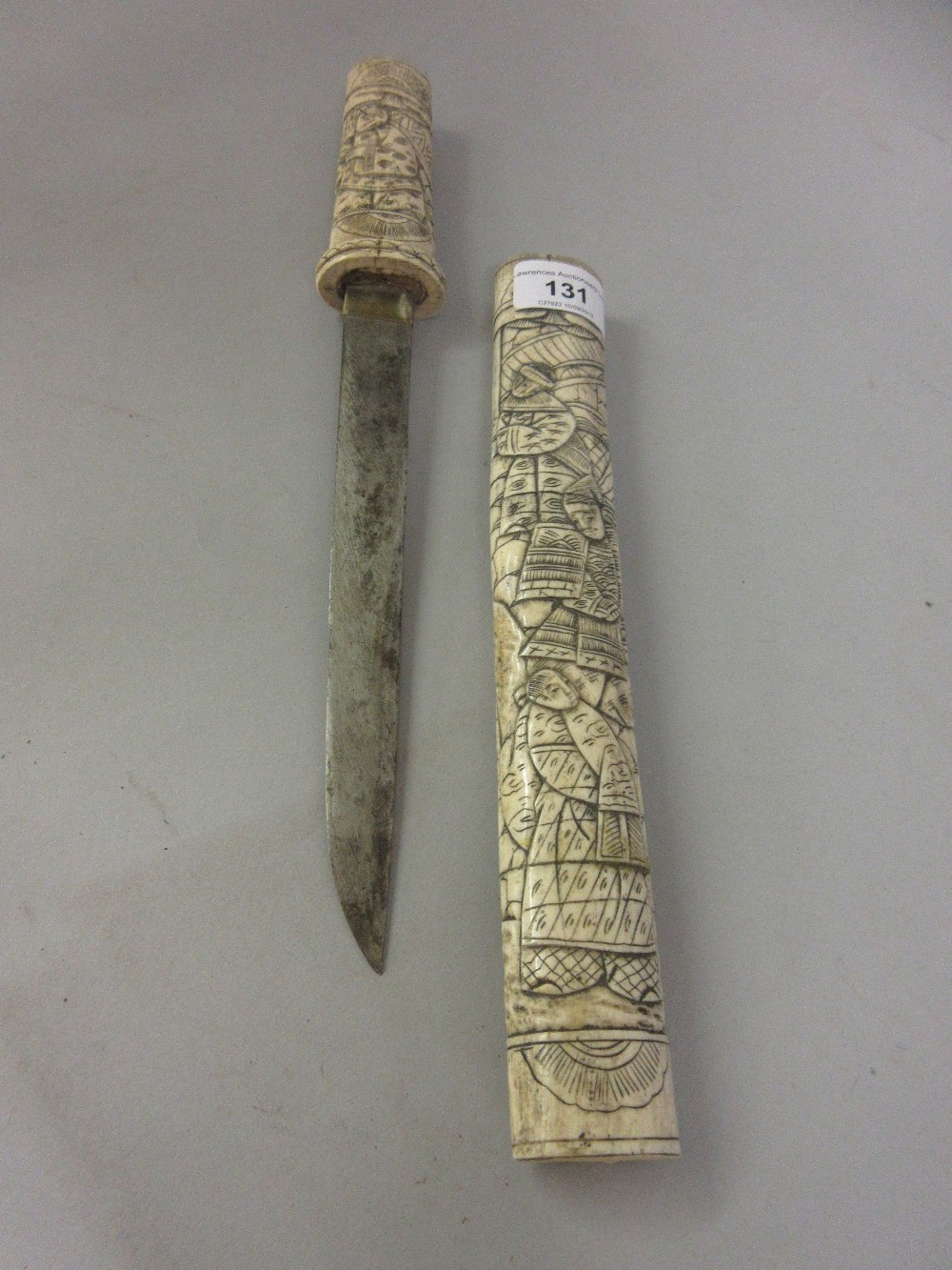 Japanese dagger, the bone grip and scabbard carved with various figures