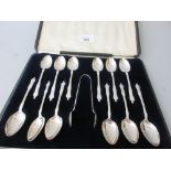 Cased set of twelve silver Apostle handled teaspoons with matching sugar tongs