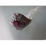 White metal Edwardian style diamond and ruby dress ring with a central oval shaped ruby