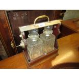 Edwardian mahogany and satinwood crossbanded two bottle tantalus with two cut glass decanters (glass