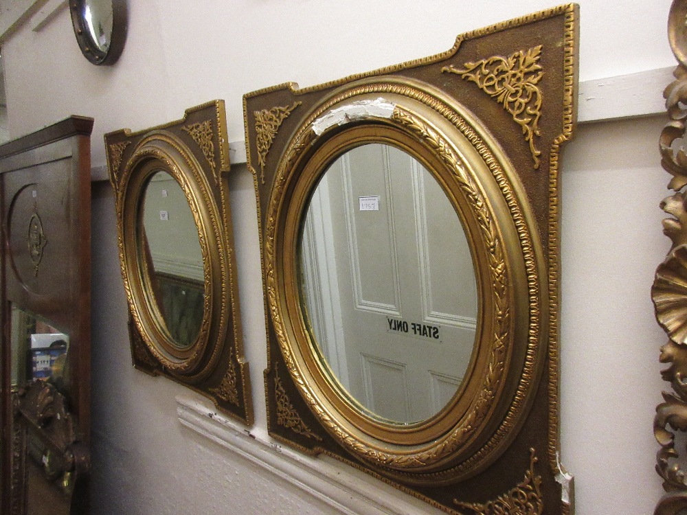 Pair of oval gilt moulded composition wall mirrors (one at fault) Some losses to moulding on one