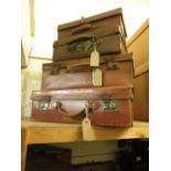 Early 20th Century leather suitcase, together with three smaller simulated leather suitcases