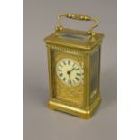 Edwardian gilt brass carriage clock, the circular dial with Roman numerals and ornate cast gilt