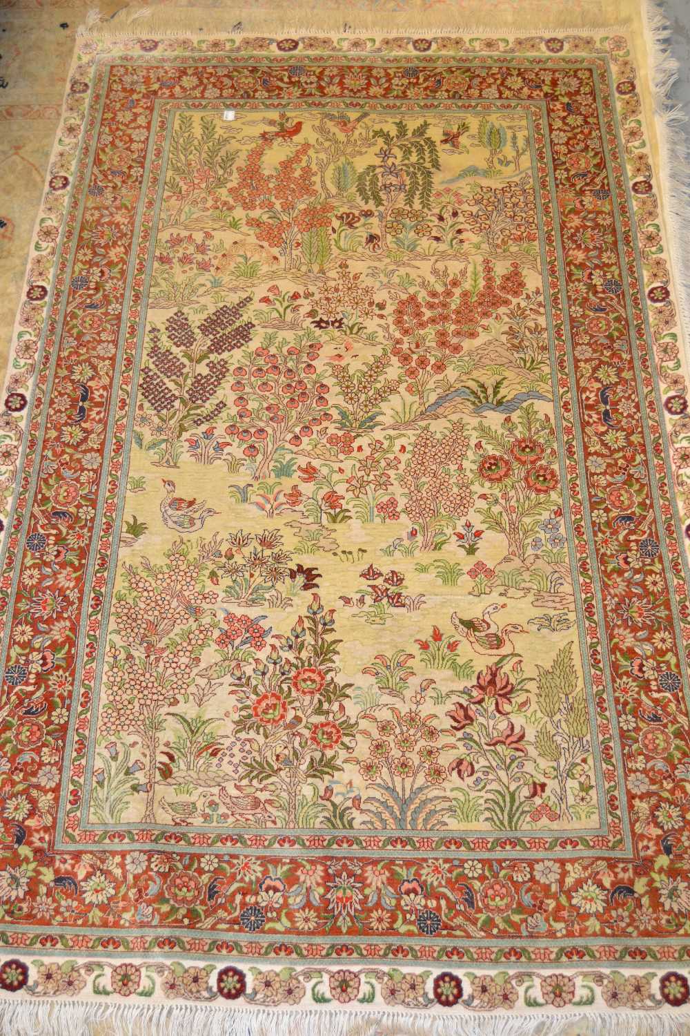 Turkish silk rug decorated with birds in a landscape, approximately 60ins x 36ins Some losses to