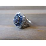 Platinum ring set central sapphire bordered by calibre cut sapphires and diamonds
