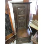 Tall and narrow antique carved oak settle with a three panel back above a box seat and a two panel
