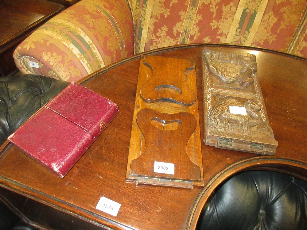 19th Century sliding book rack, a North African carved hardwood book rack and a leather photograph