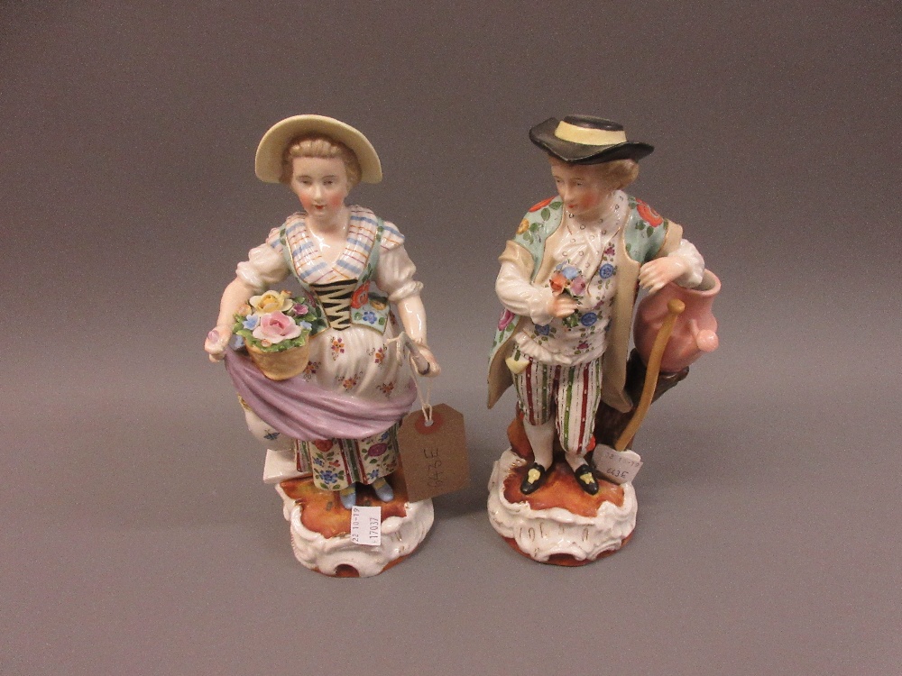 Pair of 19th Century continental porcelain figures, boy with a posy and girl with basket and sickle,