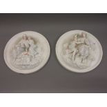 Pair of Continental circular bisque wall plaques decorated in high relief with figures (one at