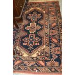 Afghan rug of triple medallion with multiple borders on a blue ground, 72ins x 45ins (at fault),