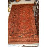 Belouch rug having a line of four gols with multiple borders on a rust ground, 5.5ft x 4ft, together